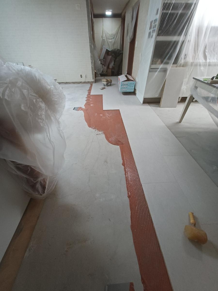 복도 바닥에서 수공구로 자재를 다듬는 장면