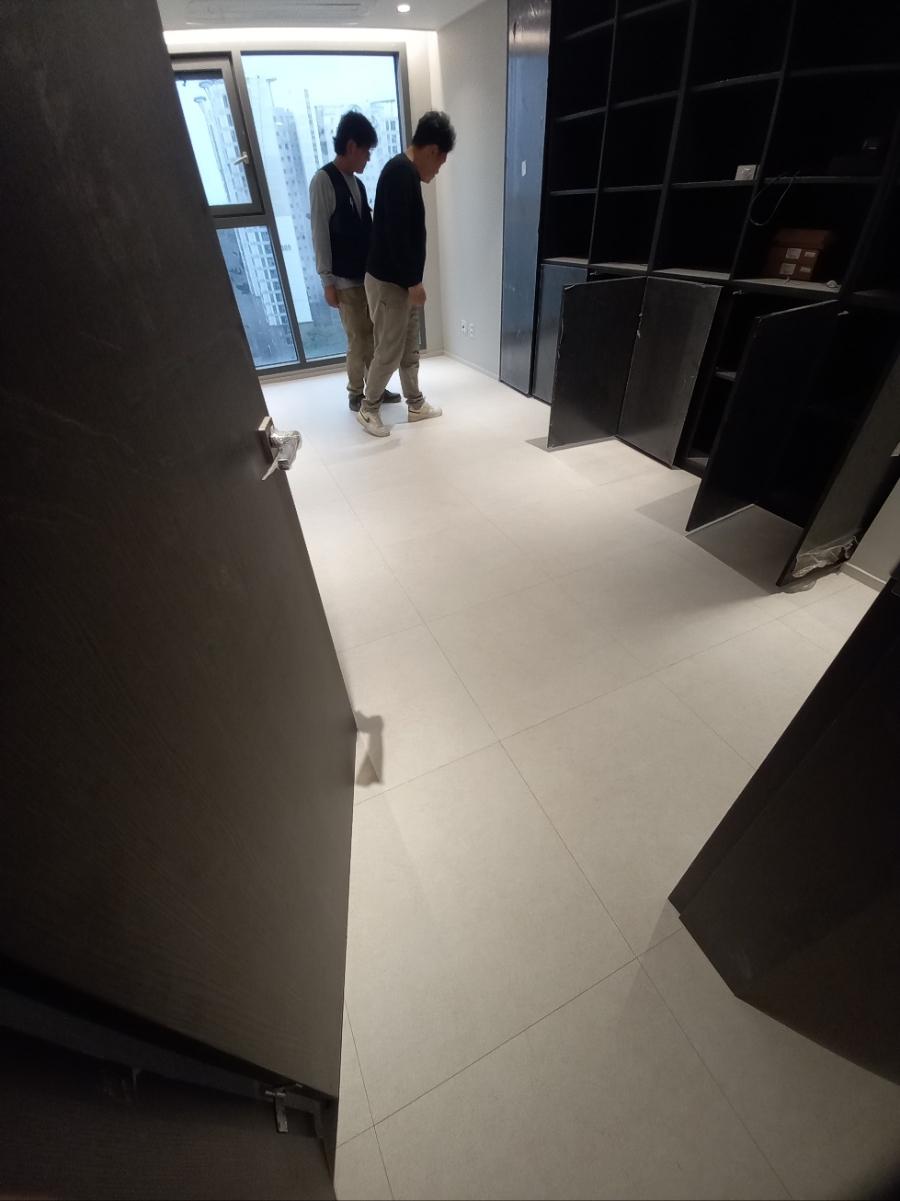 창가 쪽 검은색 수납장과 흰색 바닥