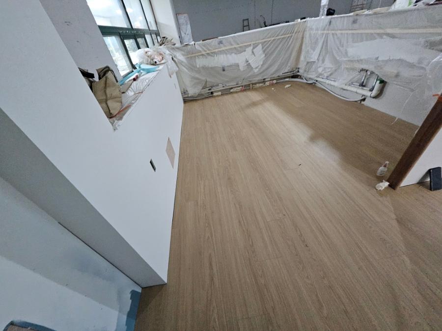 흰색 벽면과 창가 방수막이 설치된 시공 중인 내부