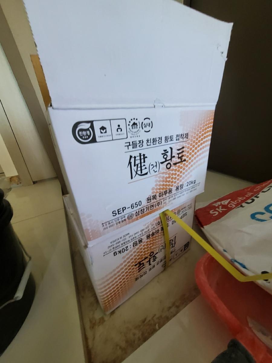 베이지색 타일 바닥 위에 놓인 자재 박스와 소품