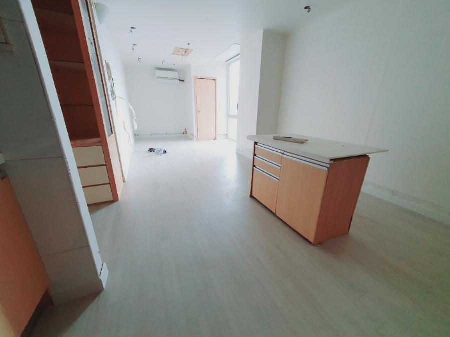 목재 수납장과 카운터가 있는 넓은 공간의 바닥 정리 상태
