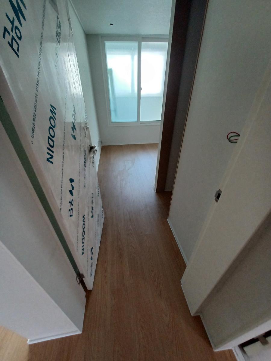 마루가 깔리기 시작한 복도와 슬라이딩 창문