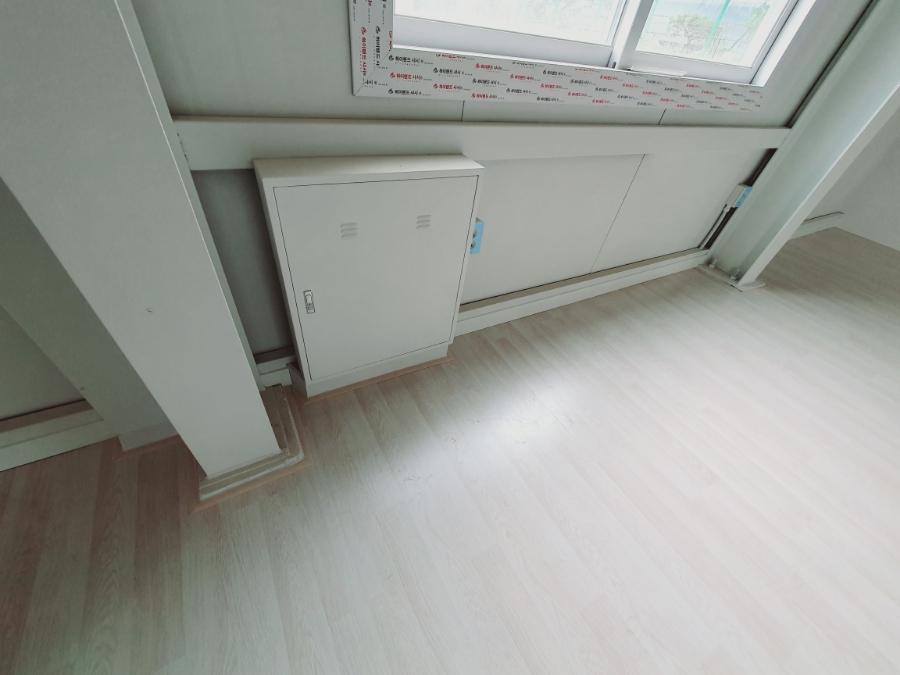 백색 수납장과 전기 박스가 설치된 벽면