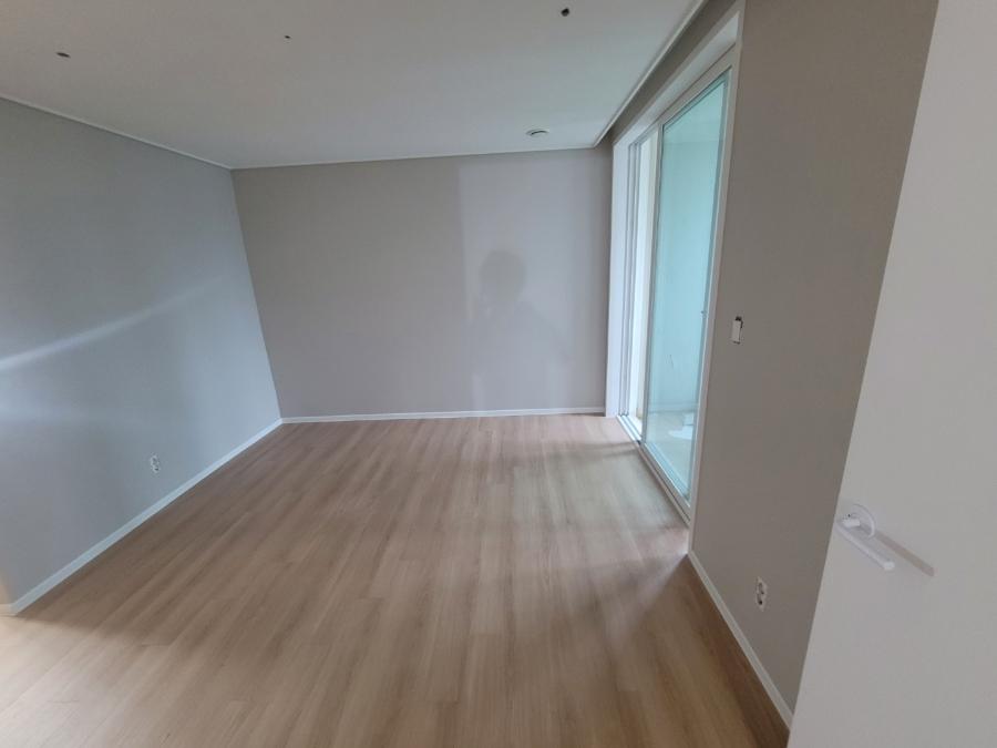 회색 벽면과 목재 마루가 만나는 방 내부
