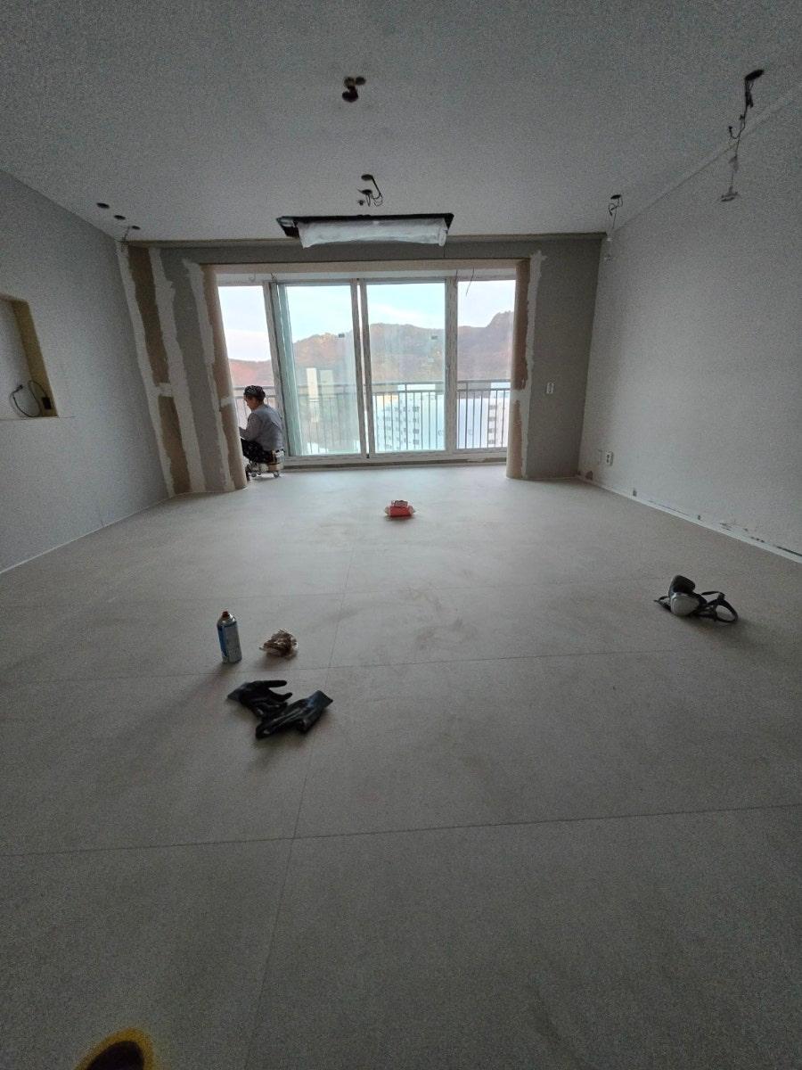 창문 근처에서 작업 중인 인물과 안전모가 보이는 현장