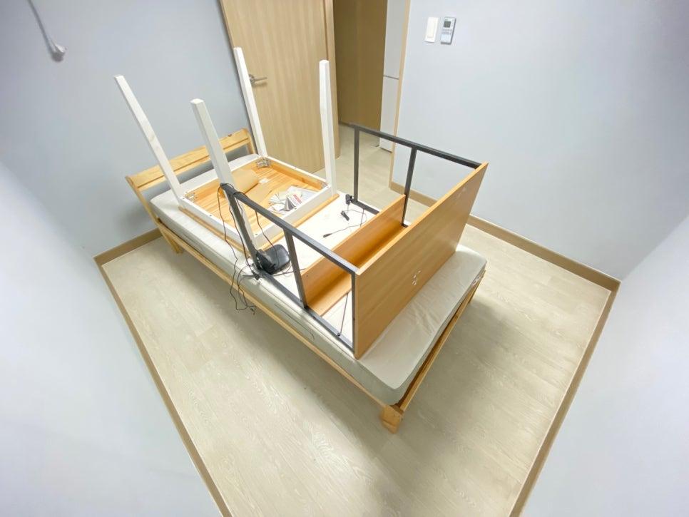 목재 프레임 침대와 벽면 조명이 있는 침실