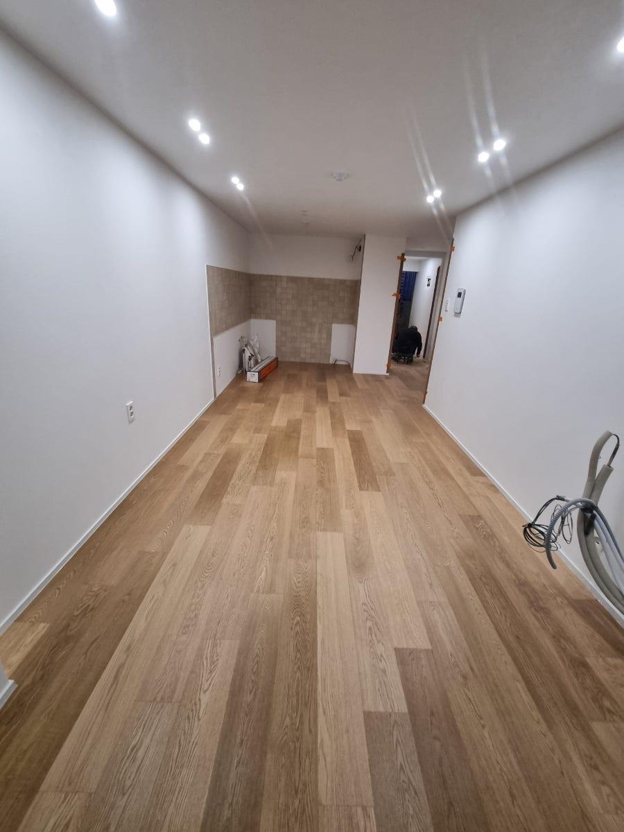 화이트 벽면과 우드 바닥이 완성된 깨끗한 복도