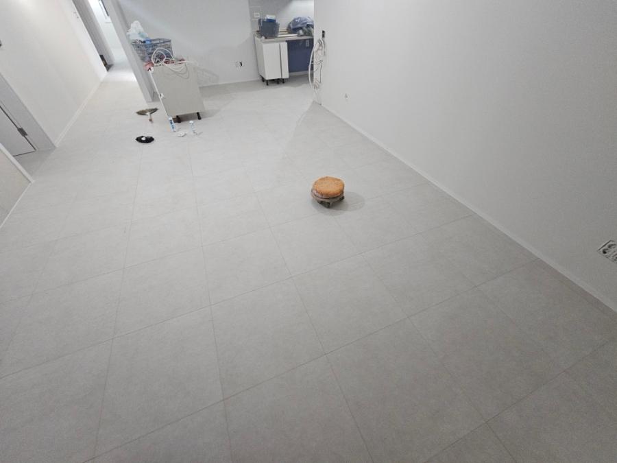 흰 벽과 타일 바닥이 있는 복도 공간의 모습