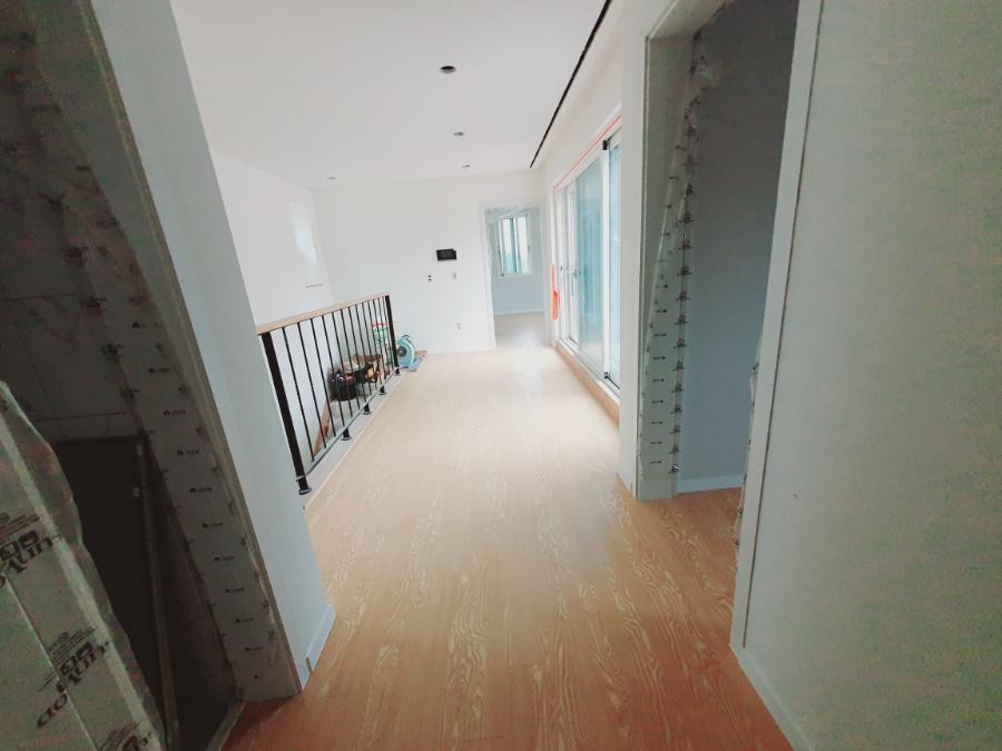 검은색 난간과 대비되는 따뜻한 톤의 복도 마루
