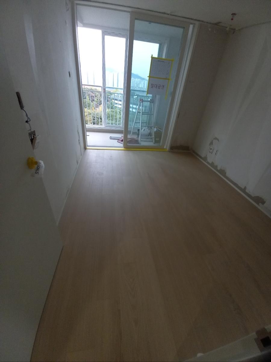 흰 벽과 목재 바닥이 만나는 창가 모습