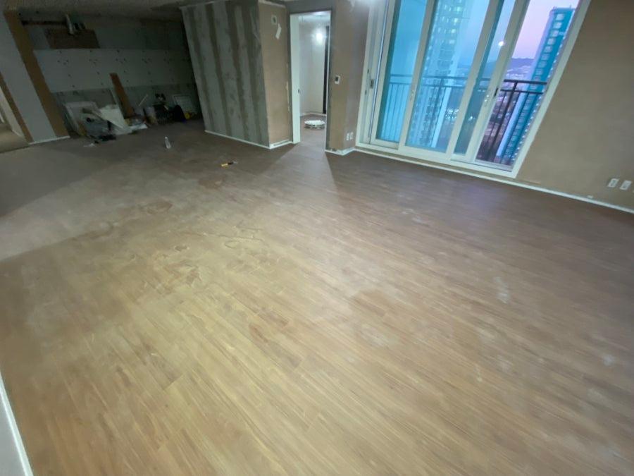 도배 전 벽면과 목재 마감재가 깔린 넓은 실내