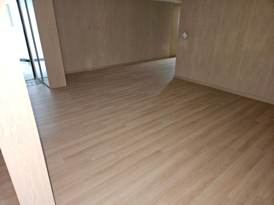 목재 패널 벽면과 바닥재가 적용된 실내 공간