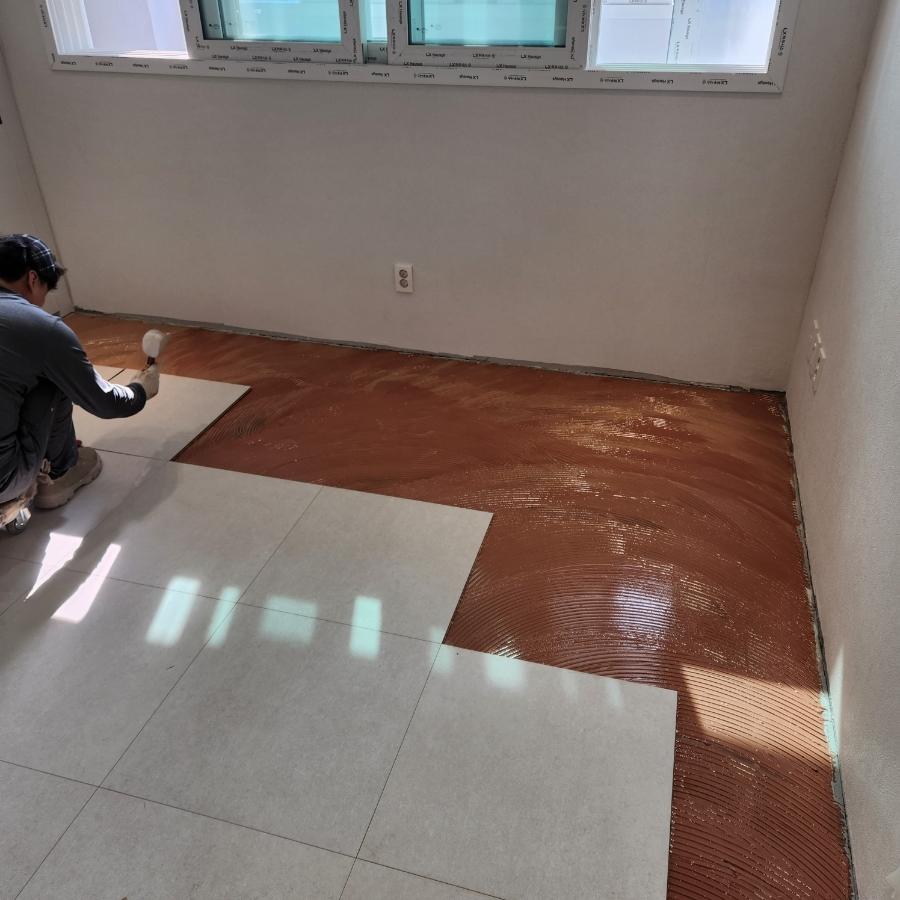 백색 프레임 창호와 붉은 접착제가 발린 바닥
