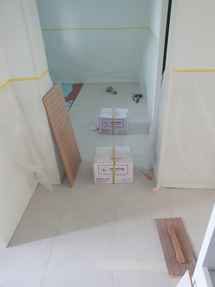 마루 시공 중인 장면과 손잡이가 보이는 도구