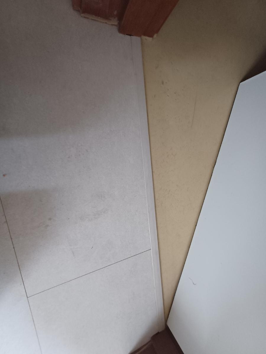 타일 바닥과 베이지색 벽면의 접합부 근접 샷