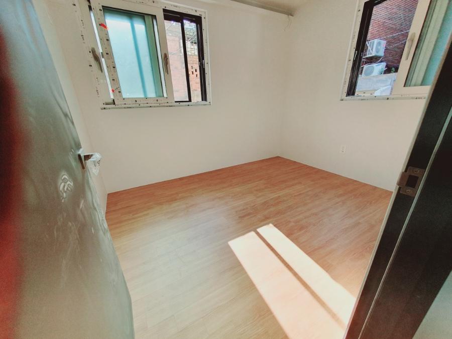 창호 두 개가 설치된 방의 목재 바닥 상태