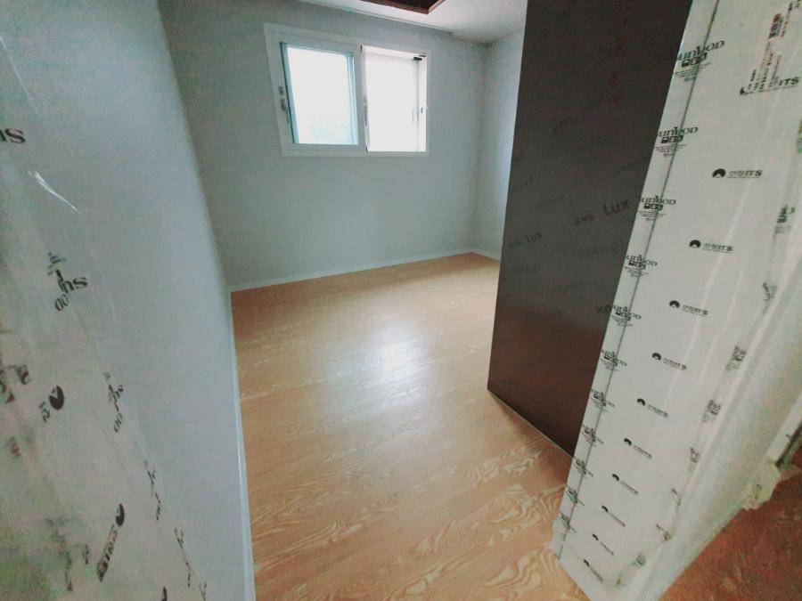 흰색 프레임 창호와 마루가 만나는 실내 공간