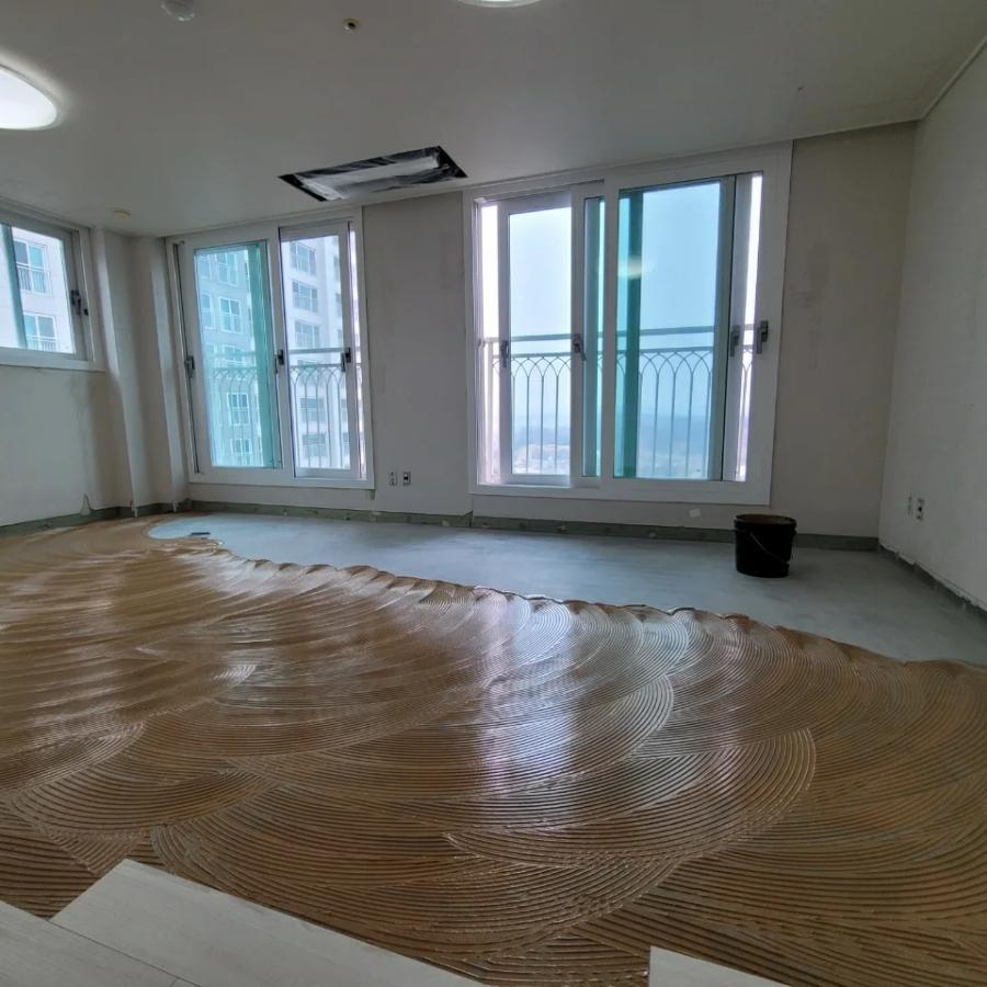 바닥에 마감재가 펼쳐진 창가 쪽 작업 현장