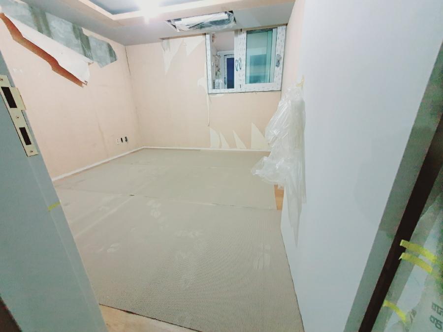 바닥재 마감 전 텅 빈 상태의 실내 공간