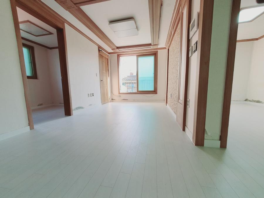 목재 프레임과 창호가 있는 복도 공간의 시공 과정