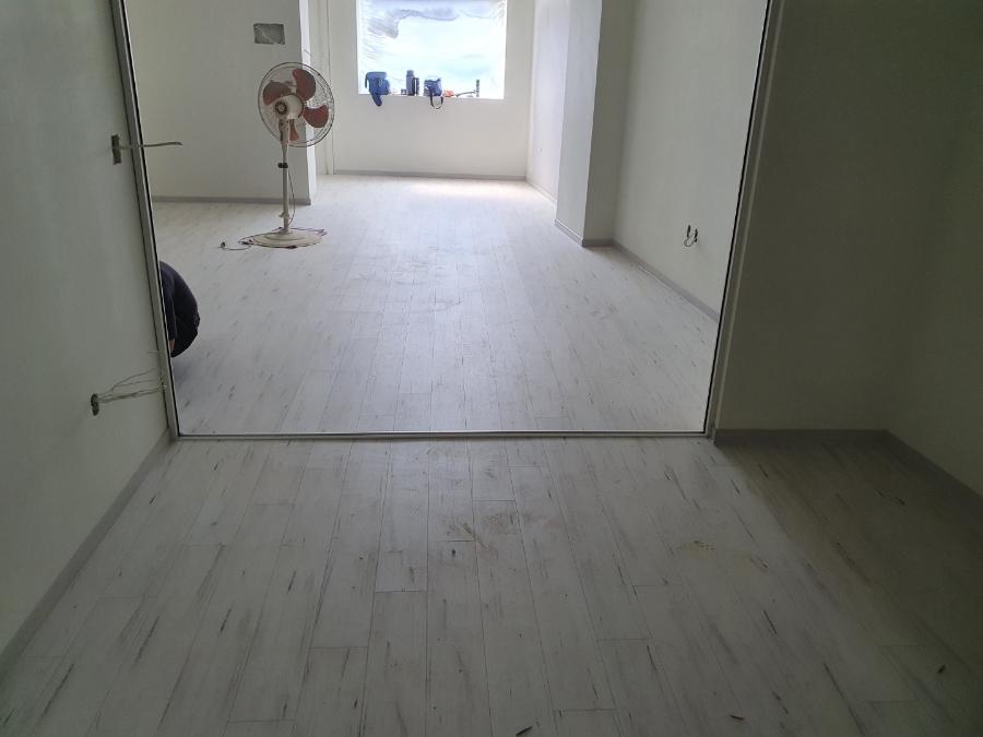 선풍기가 놓인 넓은 공간의 마루 시공 모습