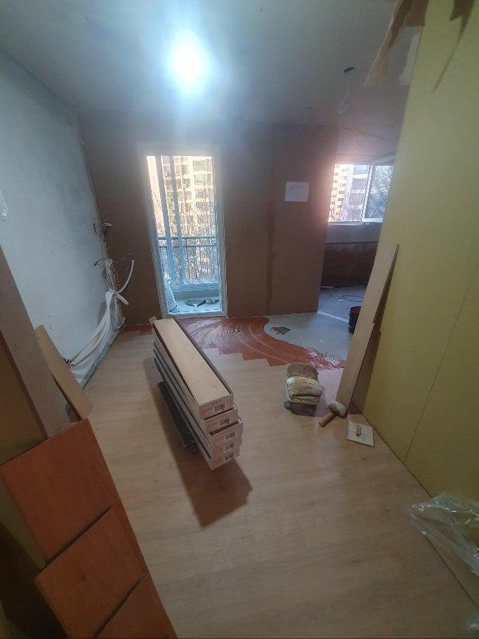 타일 작업과 목재 자재가 배치된 현장