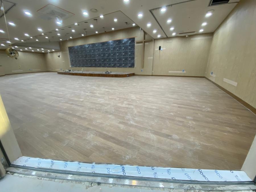 검은색 패널 벽면과 맞닿은 목재 바닥