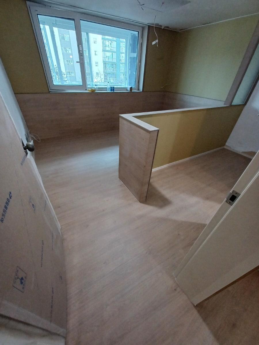 베이지색 도배와 목재 마루가 적용된 실내