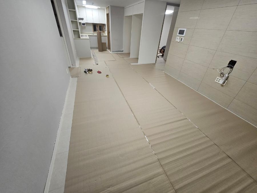 전기 소켓이 설치된 베이지색 타일 바닥의 복도