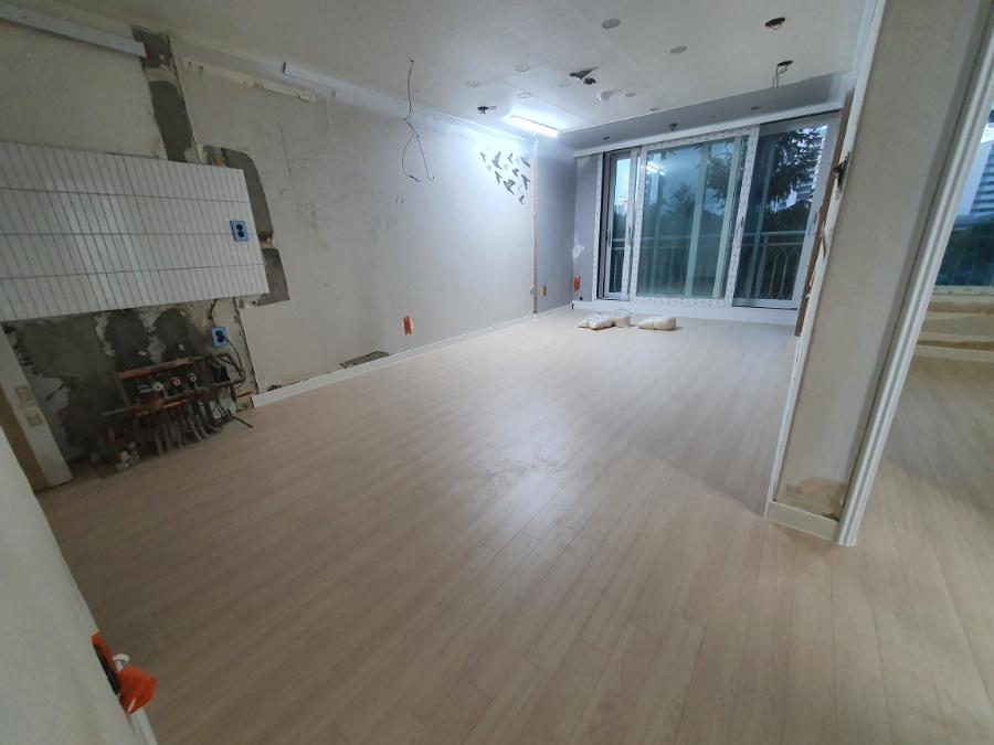 흰색 페인트 벽면과 목재 마루가 만나는 시공 지점