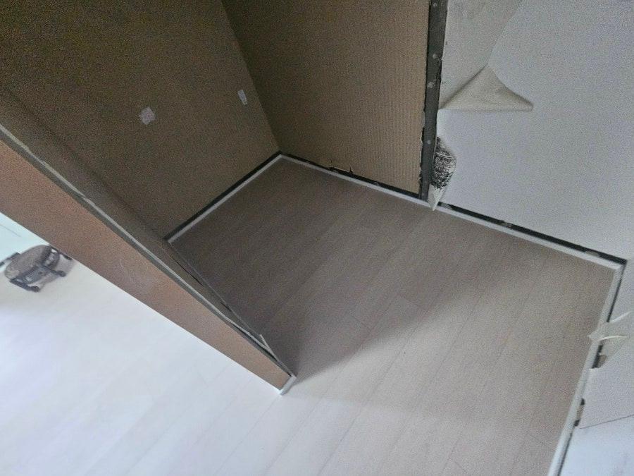 마감 전의 벽면과 흰색·갈색 계열의 바닥 타일