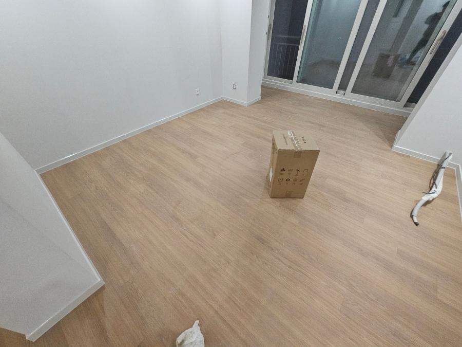 흰 벽과 목재 바닥이 깔린 빈 방
