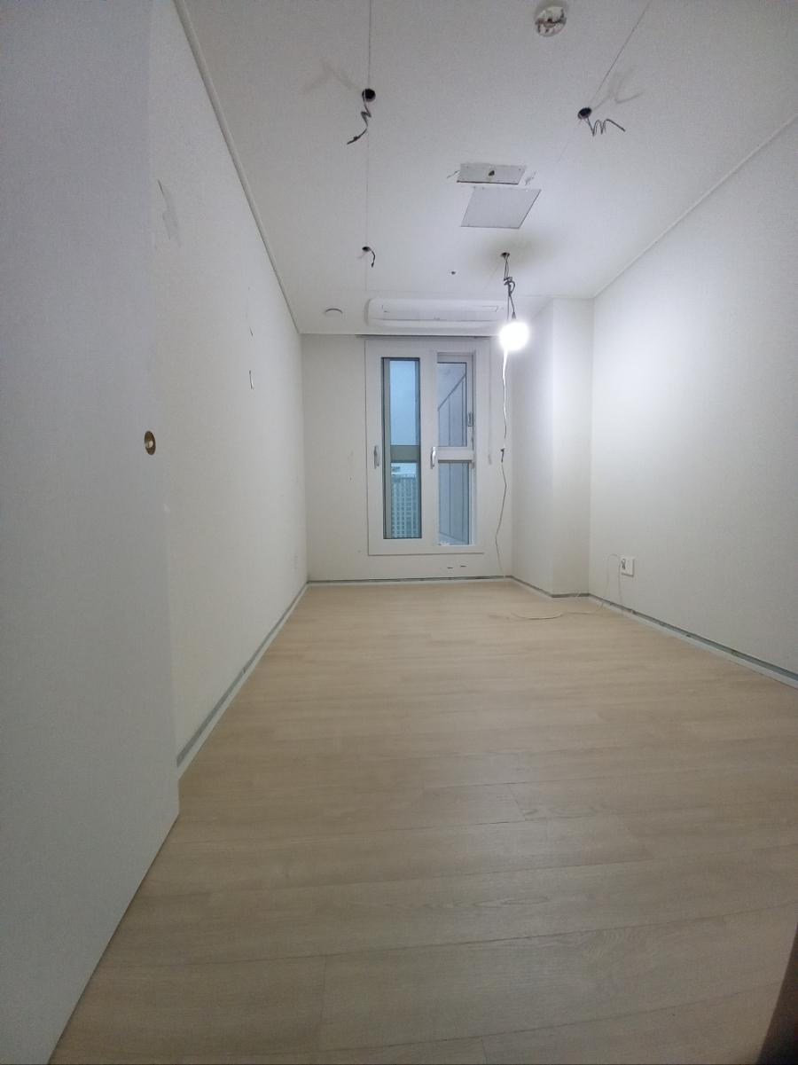 유리문 창호와 목재 바닥이 만나는 복도