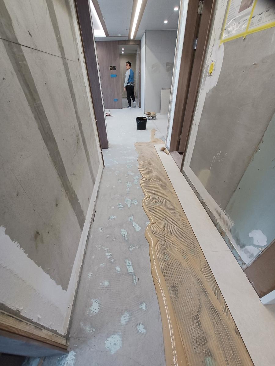복도 바닥에 마루 자재를 설치 중인 과정