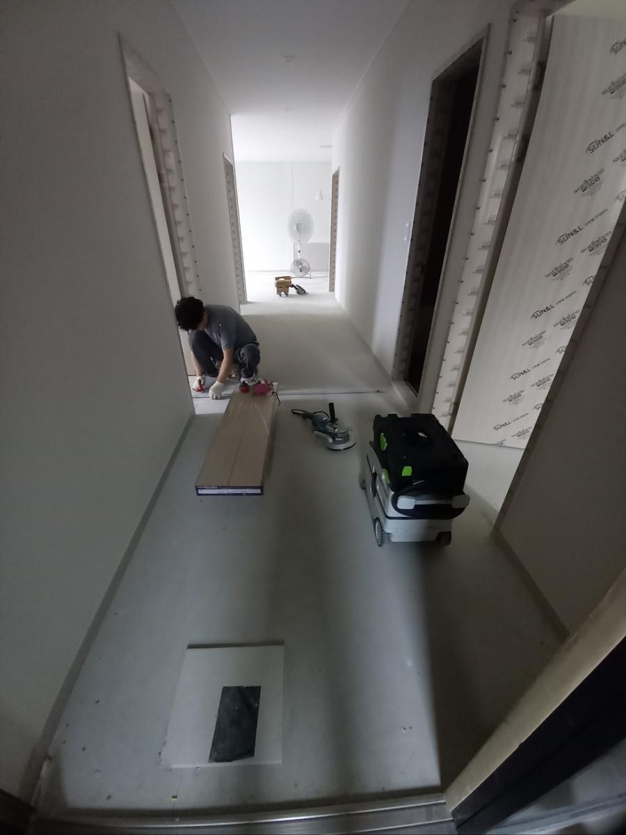 작업자와 타일 자재가 보이는 복도 시공 현장