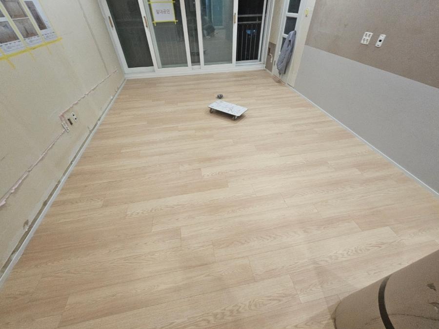 창호가 설치된 빈 실내의 목재 바닥 모습