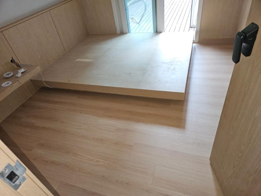 목재 마감 벽면과 수납장이 설치된 공간