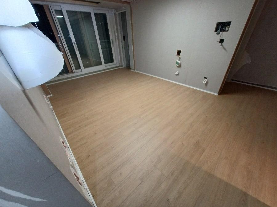 흰 벽과 목재 바닥이 어우러진 빈 실내