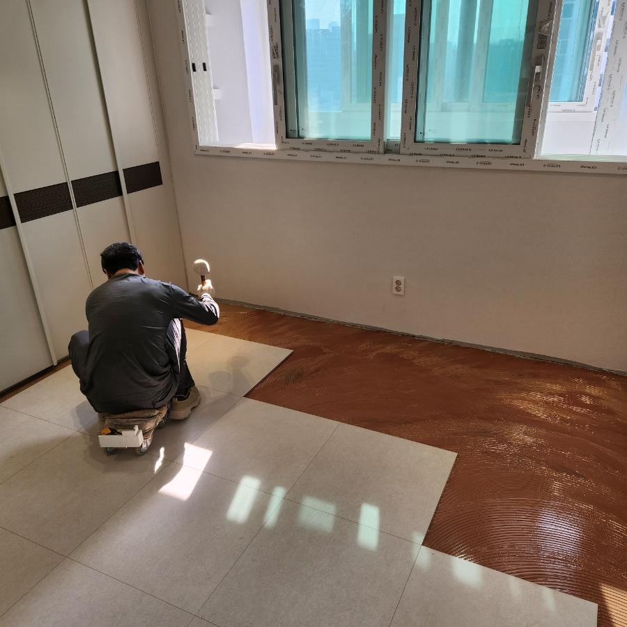 창호 아래에서 바닥 작업을 하는 모습