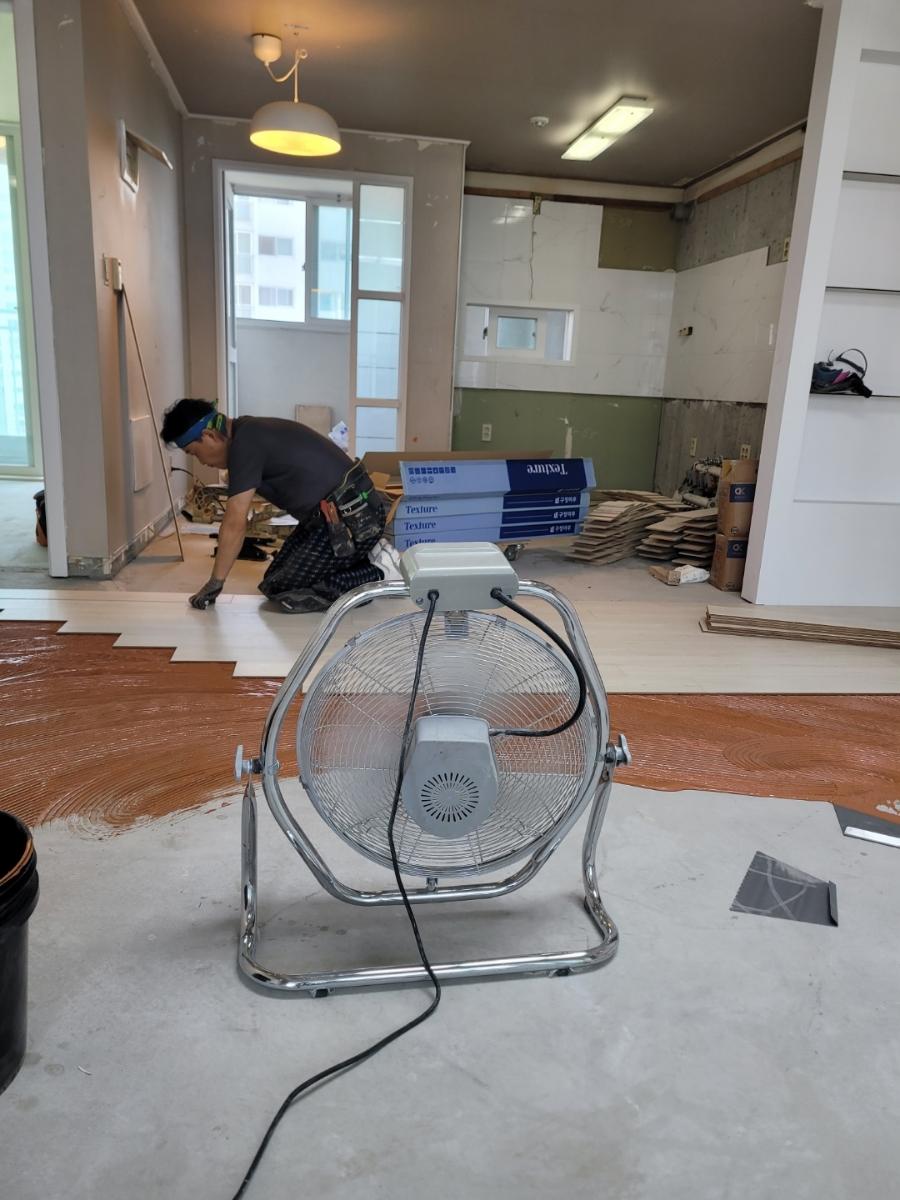 선풍기를 가동하며 바닥 작업을 진행 중인 모습