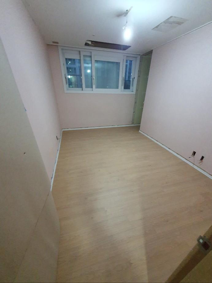흰 벽과 목재 바닥이 설치된 빈 공간