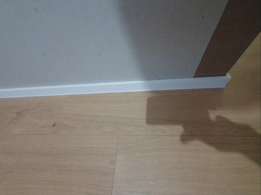 흰색 베이스보드와 목재 바닥의 접합부