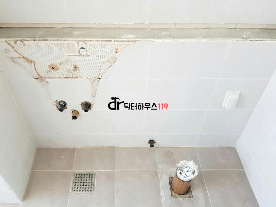철거 흔적이 보이는 흰색 타일 욕실