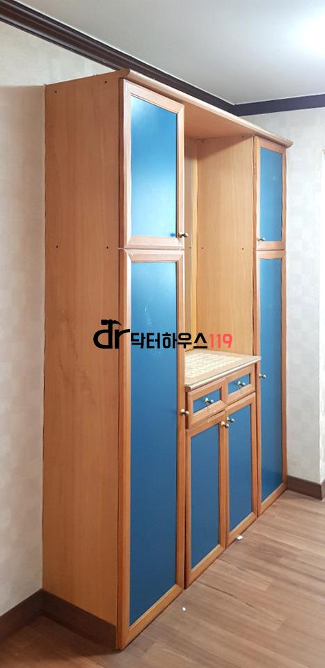 나무 톤 수납장과 파란색 문이 있는 드레스룸