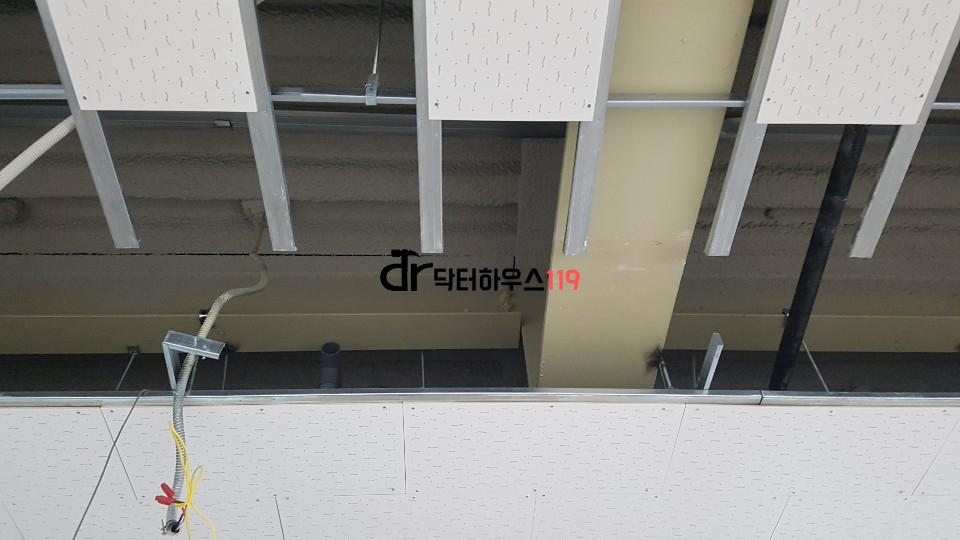 천장 내부 배관과 프레임을 조심스럽게 다루는 모습