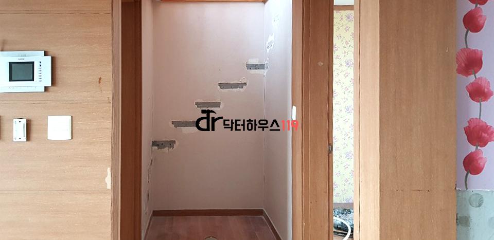 우드톤의 벽면과 바닥재가 보이는 복도