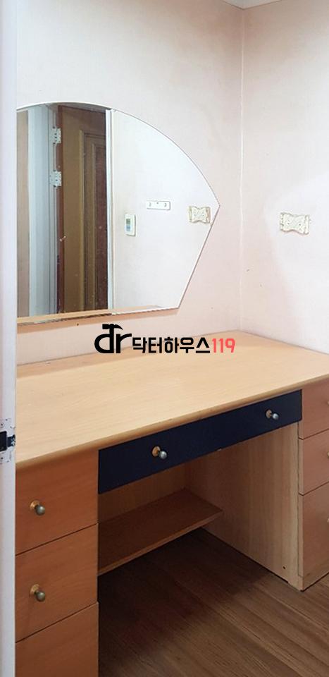 나무 톤 책상과 파란색 서랍이 있는 드레스룸