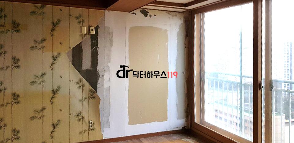 창호가 보이고 벽지가 일부 벗겨진 실내