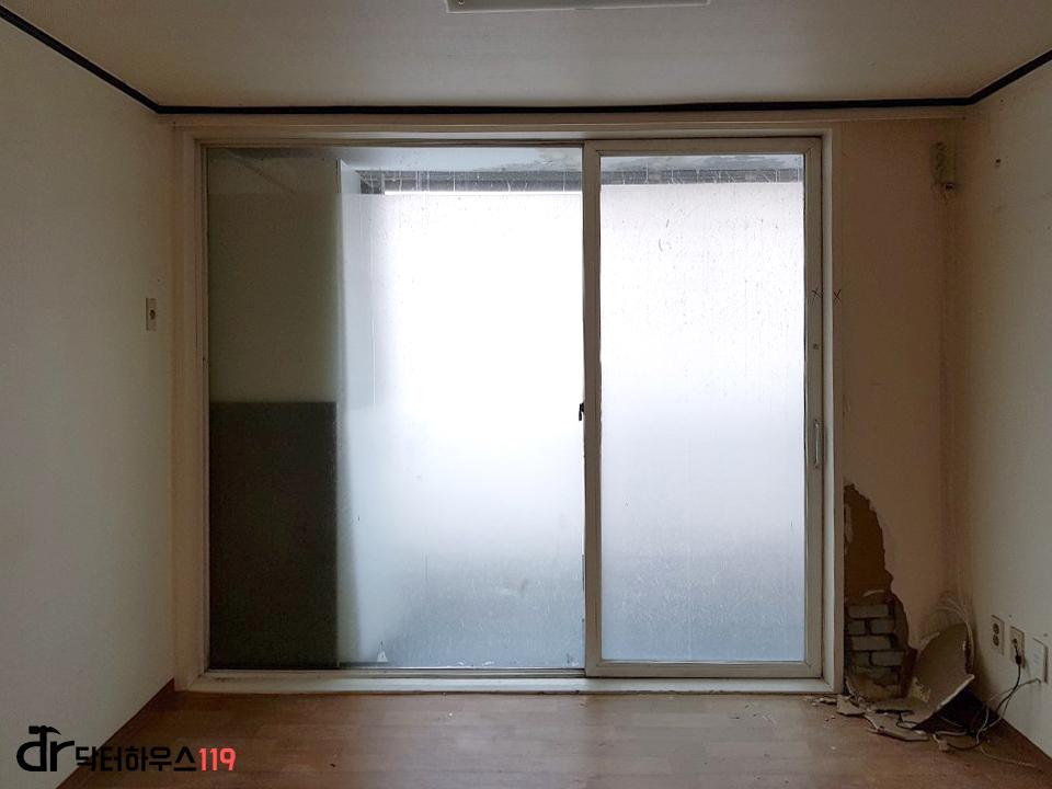 흰색 프레임의 슬라이딩 창호가 있는 방