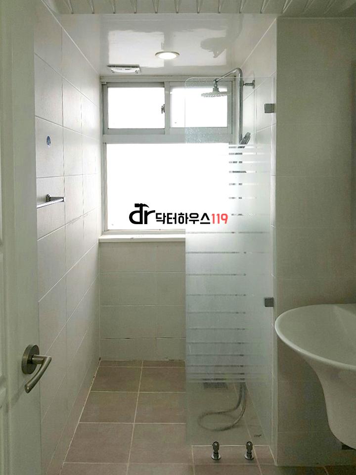 흰색 타일과 유리 부스로 완성된 욕실